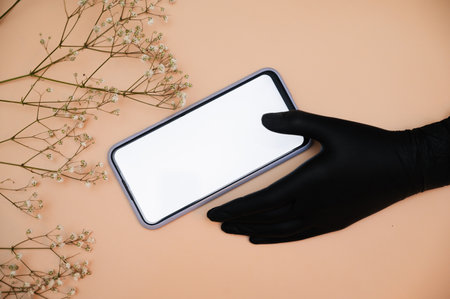 Close-up of a female manicure masters hand using her mobile phone, showing an empty space on the phone display. A place for your advertising.の写真素材