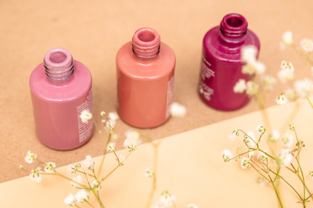 Nail polish of different colors in glass tubes stands on a light background.の写真素材