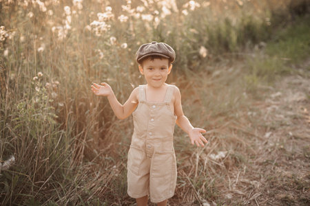 A child boy walks in a field in the village on a warm summer day. An authentic snapshot of childhood in the countryside.の写真素材