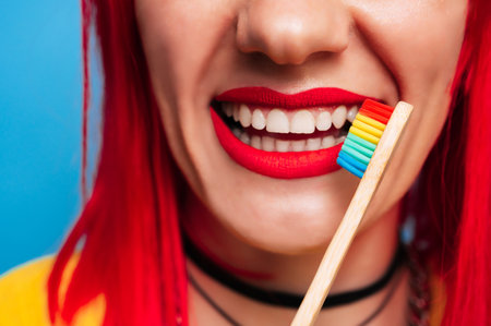 Close-up of a healthy female smile with red lipstick and a toothbrush next to it. The concept of healthy teeth, treatment and oral hygiene.の写真素材