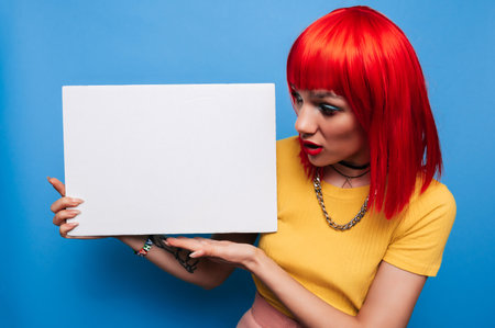 Photo of a young woman. Happy positive smile, index finger pointing to the empty space of a poster or promotional ad.の写真素材