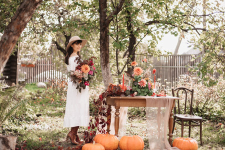 A beautiful happy woman holds a bouquet of flowers and herbs in her hands. Autumn moodの写真素材