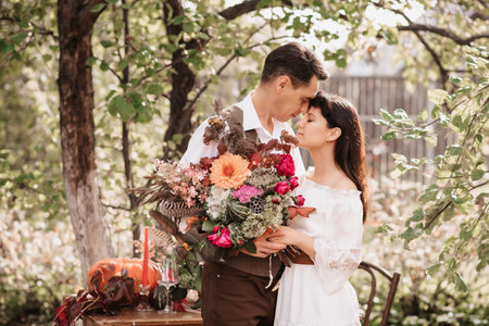 Gentle embrace of lovers a man embraces a girl with a bouquet in her hands.の写真素材