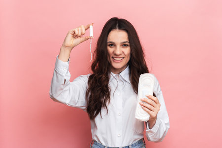 Studio shot of a young girl holding a Panty liner and tampons for menstruation.. The concept of feminine hygiene.の写真素材