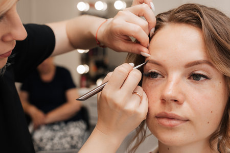 Shooting in a beauty salon. makeup artist applies makeup to the brideの写真素材