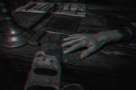 A dark and terrifying torture room. A bloody saw, medical instruments and a severed hand. Close-up. Glitch effect superimposed on the photo.の写真素材
