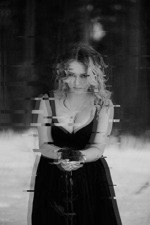 Black and white anaglyph with 3D glitch effect on portrait of a girl in the image of a dark witch.の写真素材