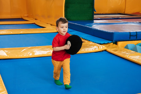 A happy boy runs and jumps on a trampoline in an entertainment center. Childhood. Active leisure.の写真素材