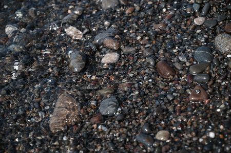 Wet small stones in seawater close-up. Pebble beachの写真素材