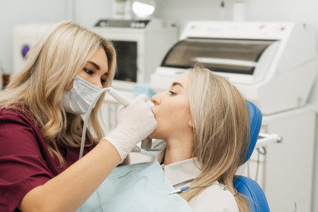 A dentist drills a female patients tooth with a medical drill.の写真素材