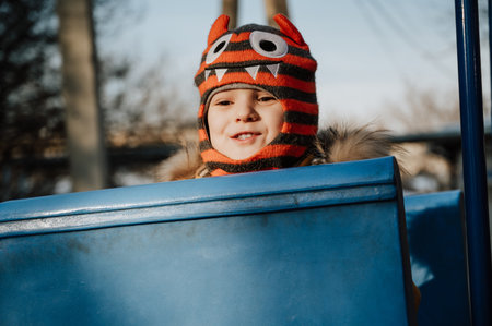 A cheerful child plays on the Playground on a snowy winter day.の写真素材