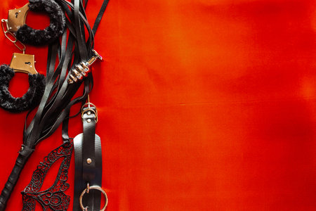 Set of toys for adults: handcuffs, anal plug, mask, whip. Space for textの写真素材