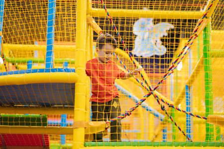 Cute baby boy playing on the playground at the childrens play centerの写真素材
