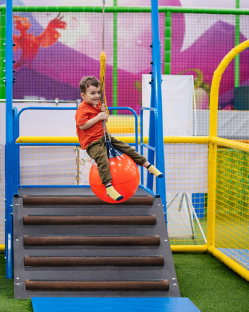 A cheerful little boy rides an amusement ride at a childrens entertainment centerの写真素材