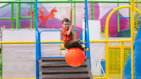A cheerful little boy rides an amusement ride at a childrens entertainment centerの写真素材