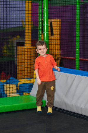 A happy boy jumps on a trampoline in an entertainment center.の写真素材