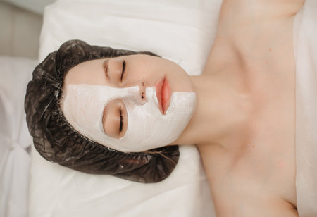 Top view of the client relaxing in the cosmetologists office with a mask on her faceの写真素材
