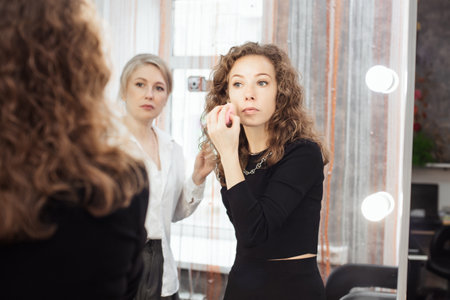 A professional makeup artist conducts a master class on professional development, observing the students work.の写真素材
