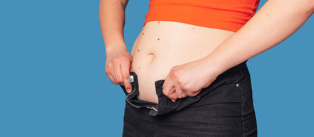 a close-up of the belly of an overweight woman, on which clothes do not fit, on a colored background. The concept of a healthy body, body positive. Panoramic banner. Copying the space.の写真素材