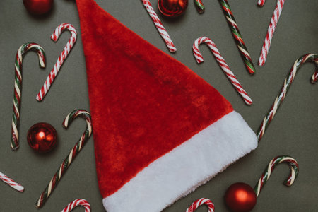 Christmas background of fir branches, balloons, caramel canes, cones and a Christmas hat.の写真素材
