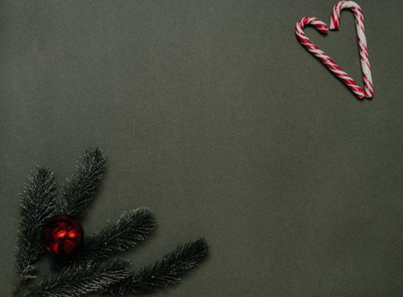 New Years frame. A frame of Christmas tree branches, cones, balls and caramel canes on a solid green background. Empty space for your ad or text.の写真素材