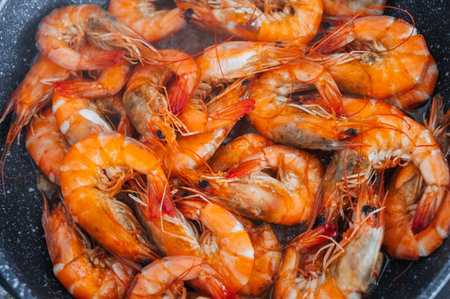 A close-up view of the shrimp fried in oil in a frying pan.の写真素材