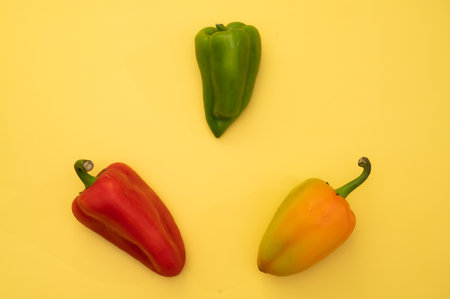 fresh peppers isolated on a bright yellow background.の写真素材