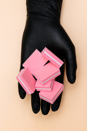A set of manicure nail files with the same abrasive in the hand of the manicure master highlighted...