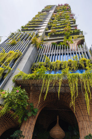 The exterior of a modern high-rise building with lush vegetation creating an inner oasis.の写真素材