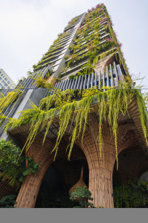 The exterior of a modern high-rise building with lush vegetation creating an inner oasis.の写真素材