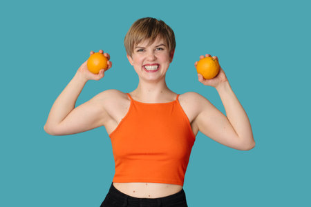 Smiling slender Caucasian girl with citrus oranges in her hands. Vitamin C.の写真素材