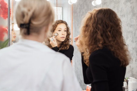 A professional makeup artist conducts a master class on professional development, observing the students work.の写真素材