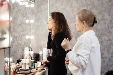 A professional makeup artist conducts a master class on professional development, observing the students work.の写真素材