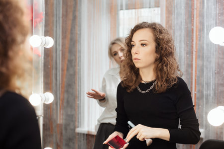 A professional makeup artist conducts a master class on professional development, observing the students work.の写真素材