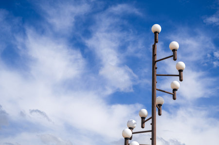 An elegant street lamp post rises above the clear blue sky