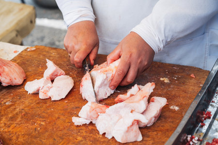 the hands of a butcher cutting lard meat.の写真素材
