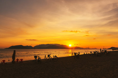 Silhouettes of people against the background of dawn on the beach in Nha Trang, Vietnam.の写真素材