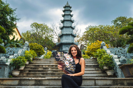 A female tourist on the background of the tower of the Buddhist temple in the Linh Ung pagoda in Da Nang in Vietnam in Asiaの写真素材