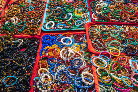 A collection of colorful, beaded bracelets and necklaces displayed at a market, featuring gemstones, pearls elementsの写真素材