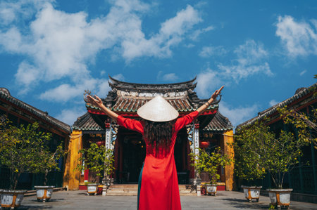 A woman in a traditional Vietnamese dress on the background Fukien Chinese Congregation Assembly Hall and Templeの写真素材