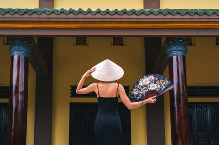 A tourist woman in a traditional Vietnamese Non La hat on the background of beautiful landscapes at the Linh Ung Son Tra pagoda in Da Nangの写真素材