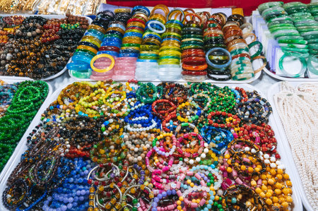 A collection of colorful, beaded bracelets and necklaces displayed at a market, featuring gemstones, pearls elementsの写真素材