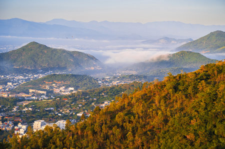 Birds-eye view of the city among the green mountains.の写真素材