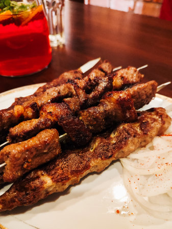 Shish kebabs are grilled meat served on a platter in a restaurant.の写真素材