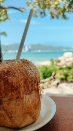 Fresh coconut on a wooden table against the background of the seaの写真素材