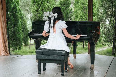 A talented pianist masterfully plays the piano outdoors in the middle of the forest.の写真素材