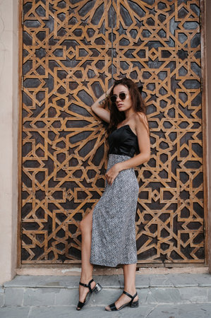 Young woman posing at a wooden door in Arabic style.の写真素材