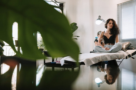 Professional female tattoo artist makes a tattoo on a womans body in the studio.の写真素材