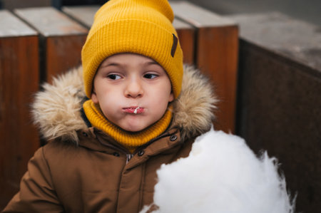 Cute baby boy eating cotton candy in the park.の写真素材