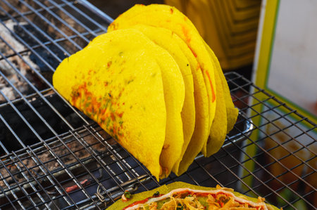 Banh Xeo. Grilled vietnamese pancake with eggs sausages and sauces in street marketの写真素材